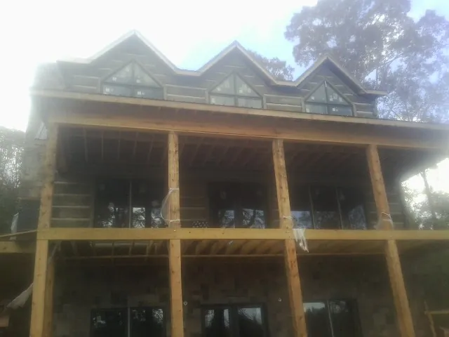 Dormers and porch framing on a large log home under construction — Roof Coating work by our crew in Taylorsville